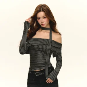 Front full view of black and gray striped off-shoulder wraparound neck-tie top with asymmetric long sleeves and black belted trousers