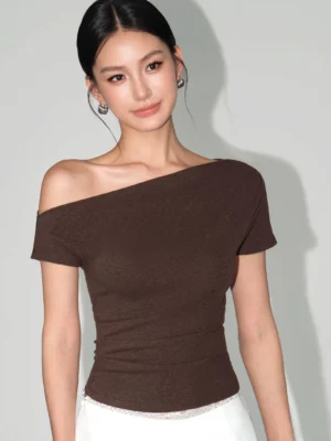 Dark brown heathered asymmetric one-shoulder slim-fit T-shirt styled with white bottoms in a minimalist studio