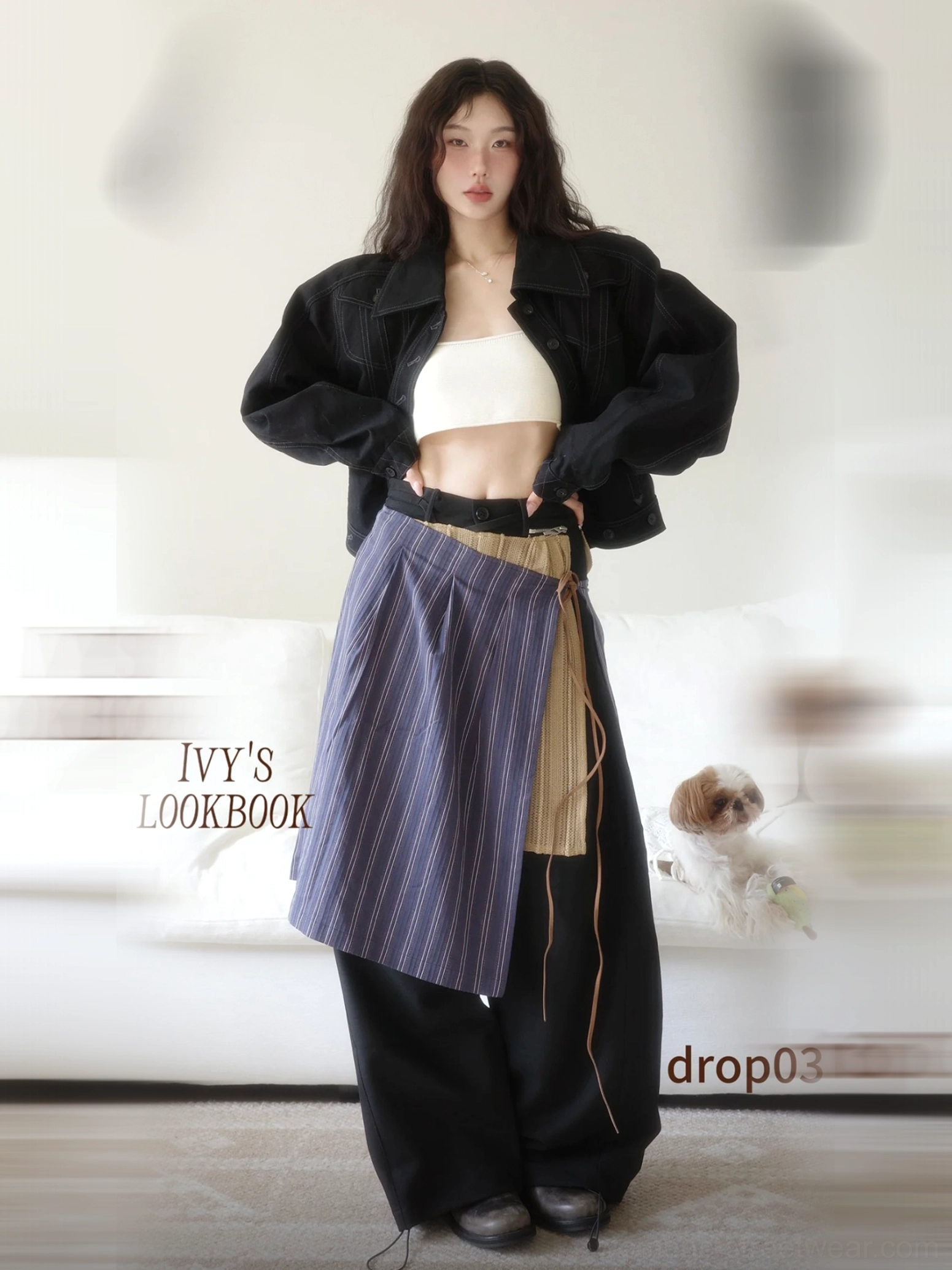 Full-body studio styling of black wide-leg streetwear pants with wrap pinstripe apron overlay and tan side panel