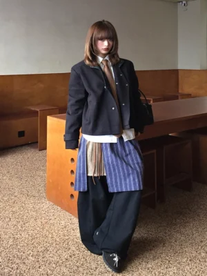 Three-quarter model view of blue pinstripe and tan layered apron balloon pants in avant-garde Korean streetwear styling