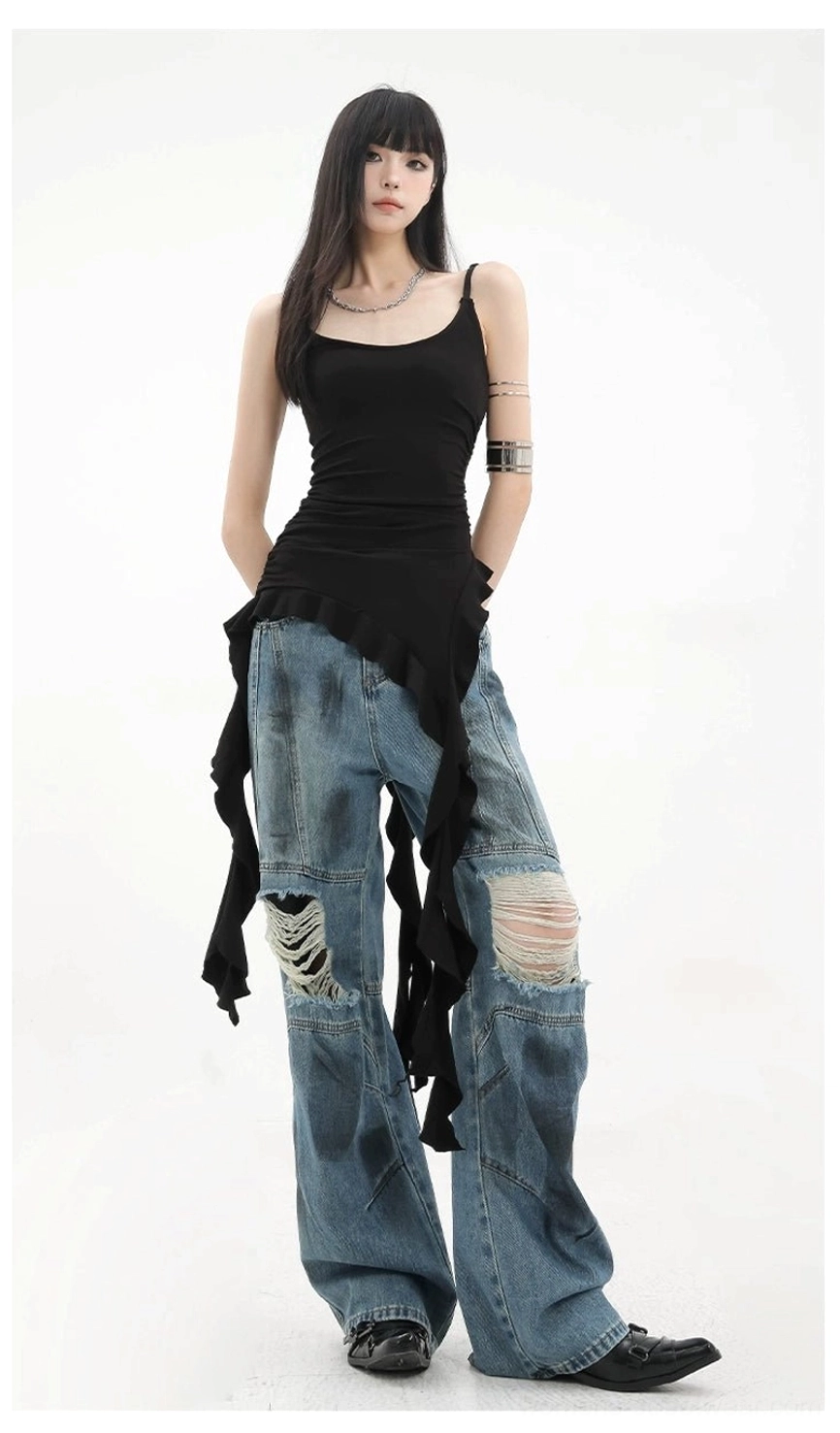 Front view of black spaghetti strap ruffle tank with irregular asymmetric hem side trailing ribbon tails and layered silver jewelry accessories