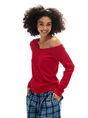 Bright red asymmetrical off-shoulder button-front knit cardigan with fitted long sleeves in a modern streetwear outfit