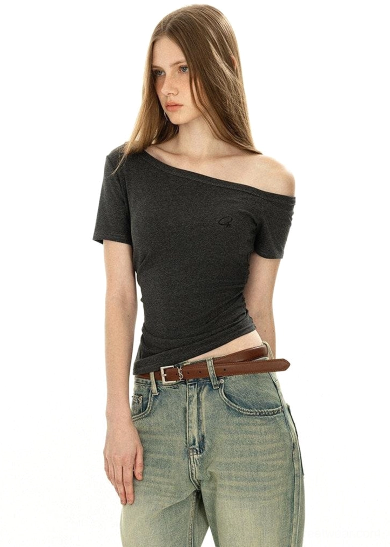 Asymmetrical one-side off-shoulder dark grey basic tee showing neckline detail with short sleeves and vintage jeans side front view
