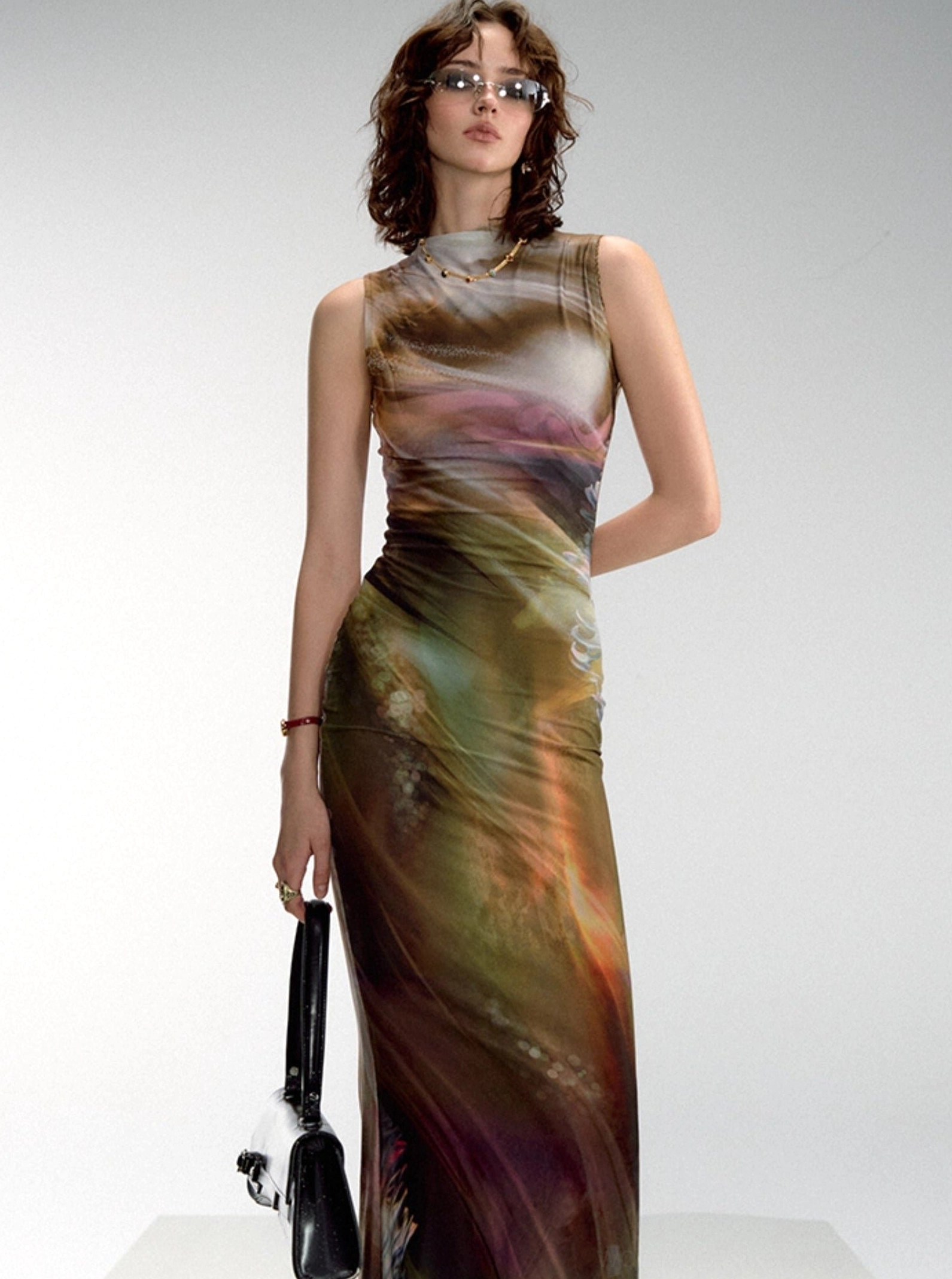 Warm-toned aurora watercolor print sleeveless fitted maxi dress with mock neck shown in a three-quarter side view