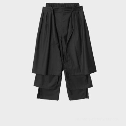 Avant-garde black wide-leg draped trousers with asymmetric apron panel and hanging strap details
