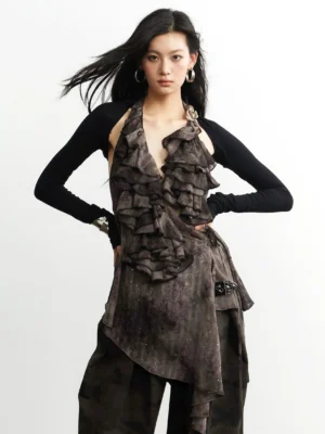 Front three-quarter view of an avant-garde layered ruffle halter top and black long-sleeve bolero set with dark brown textured fabric