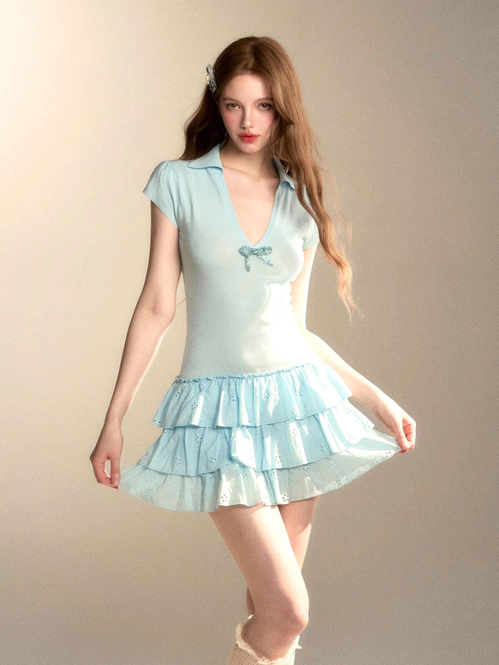 Baby blue coquette tiered ruffle mini dress with matching chest bow shown in a three-quarter front view