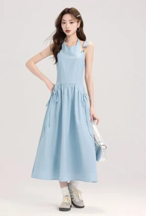 Baby blue drawstring pocket overall midi dress front three-quarter view with adjustable buckle straps and A-line skirt