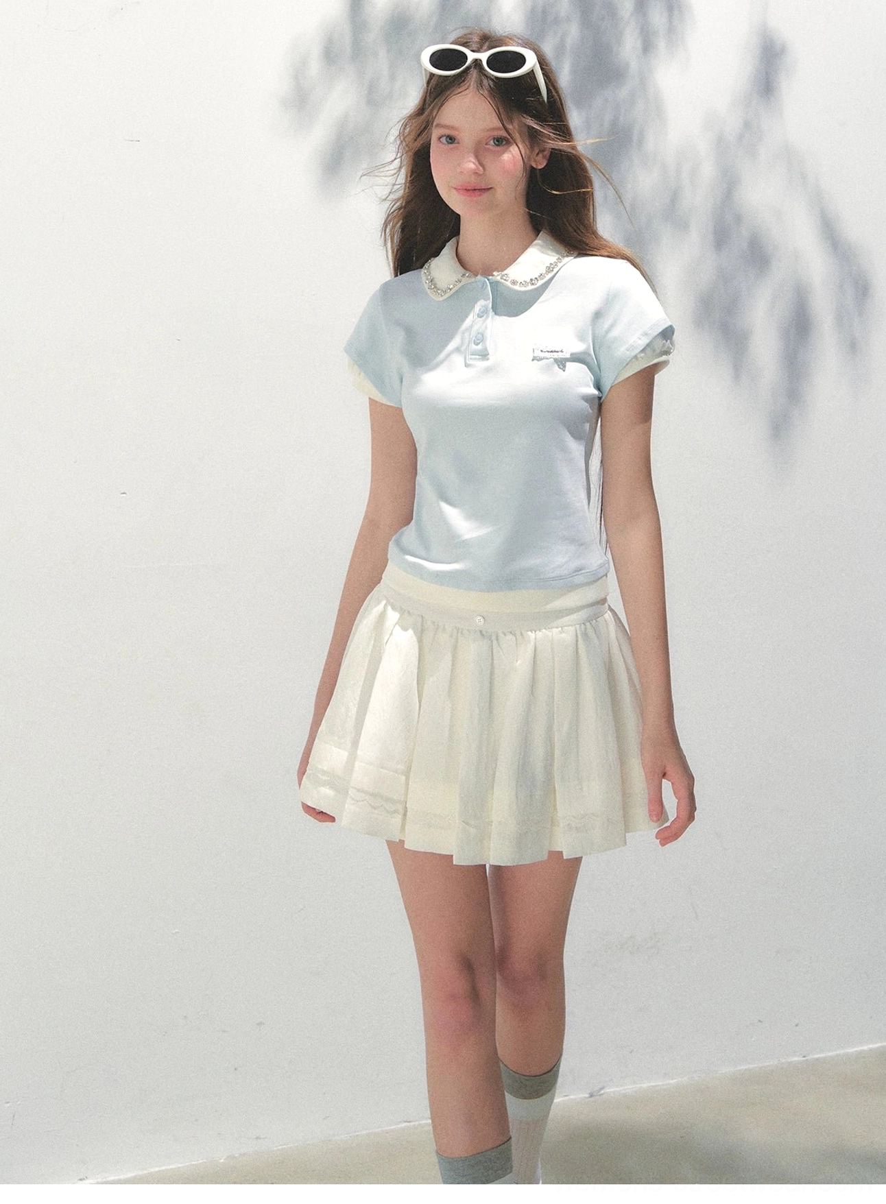 Baby blue lace collar cotton polo top paired with white pleated skirt in a full body Korean preppy outfit