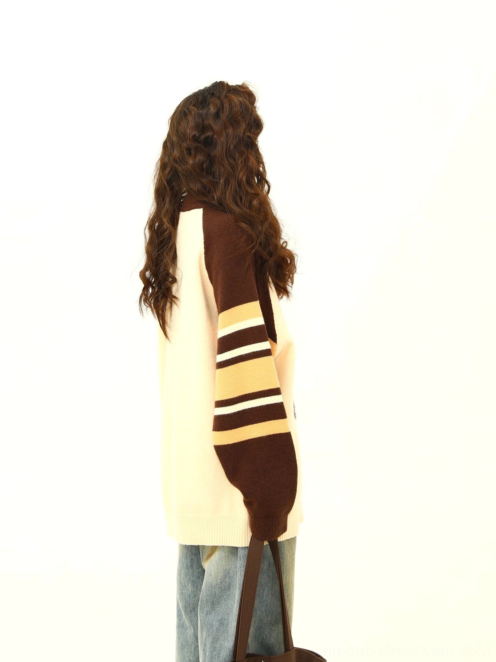 Back three-quarter view of a brown striped raglan sleeve dachshund graphic knit sweater with tote bag styling