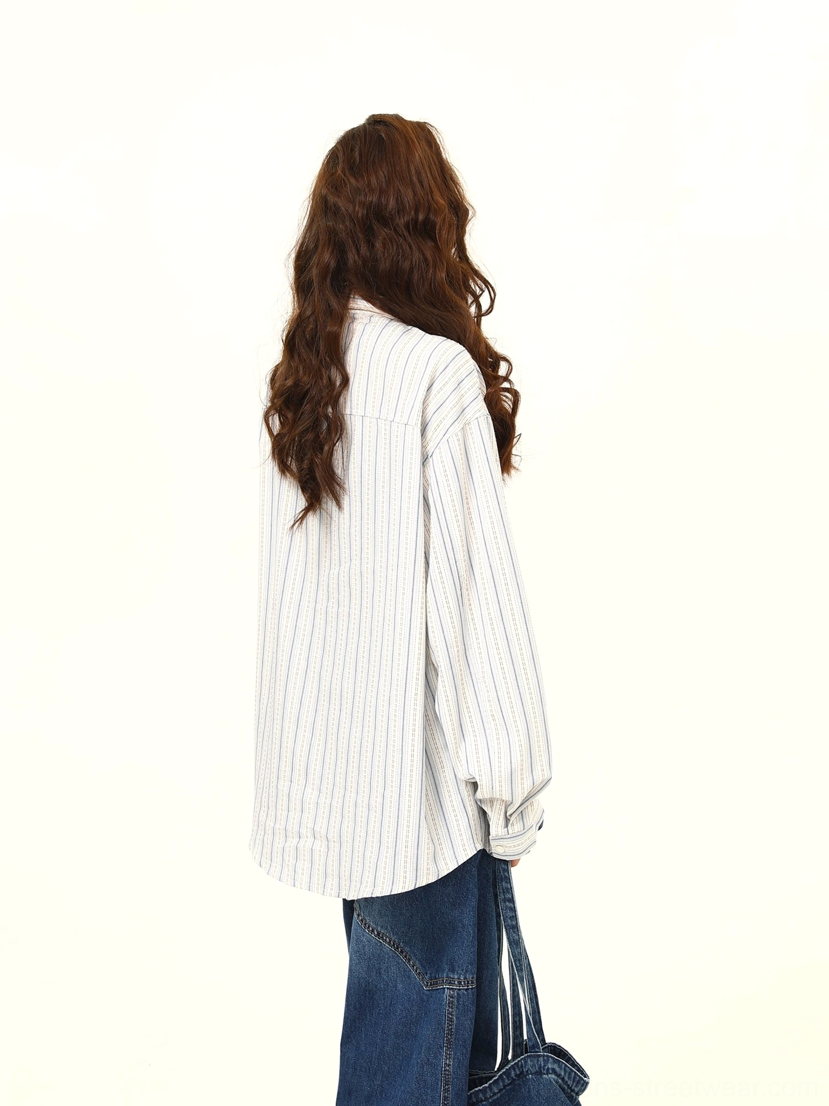 Back view of a relaxed oversized white and gray striped shirt showing its loose silhouette and contemporary Korean streetwear fit