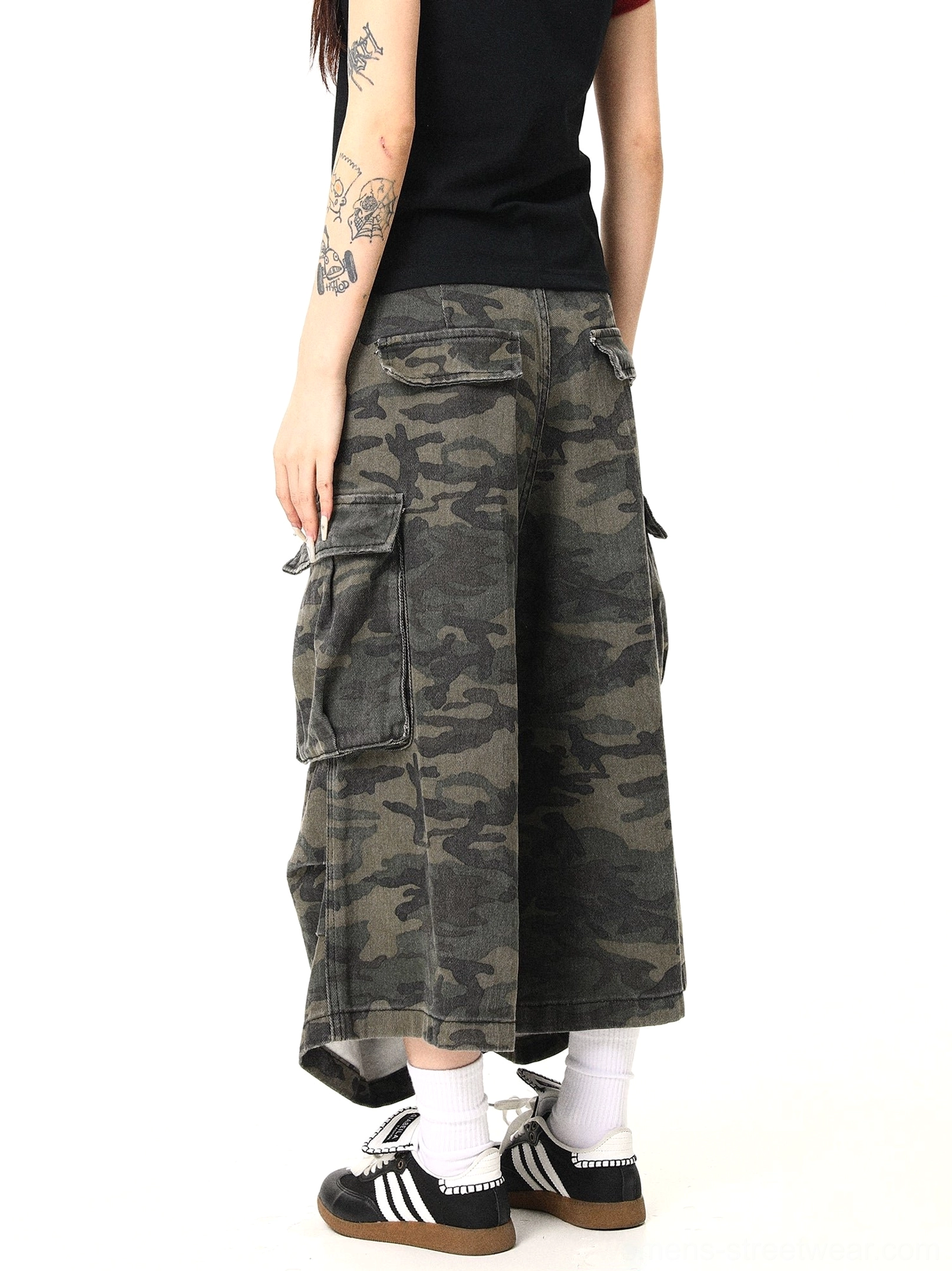 Rear view of women’s baggy military green camouflage cargo pants showing rear utility pocket details, relaxed wide-leg cut, natural high waist, and vintage streetwear texture