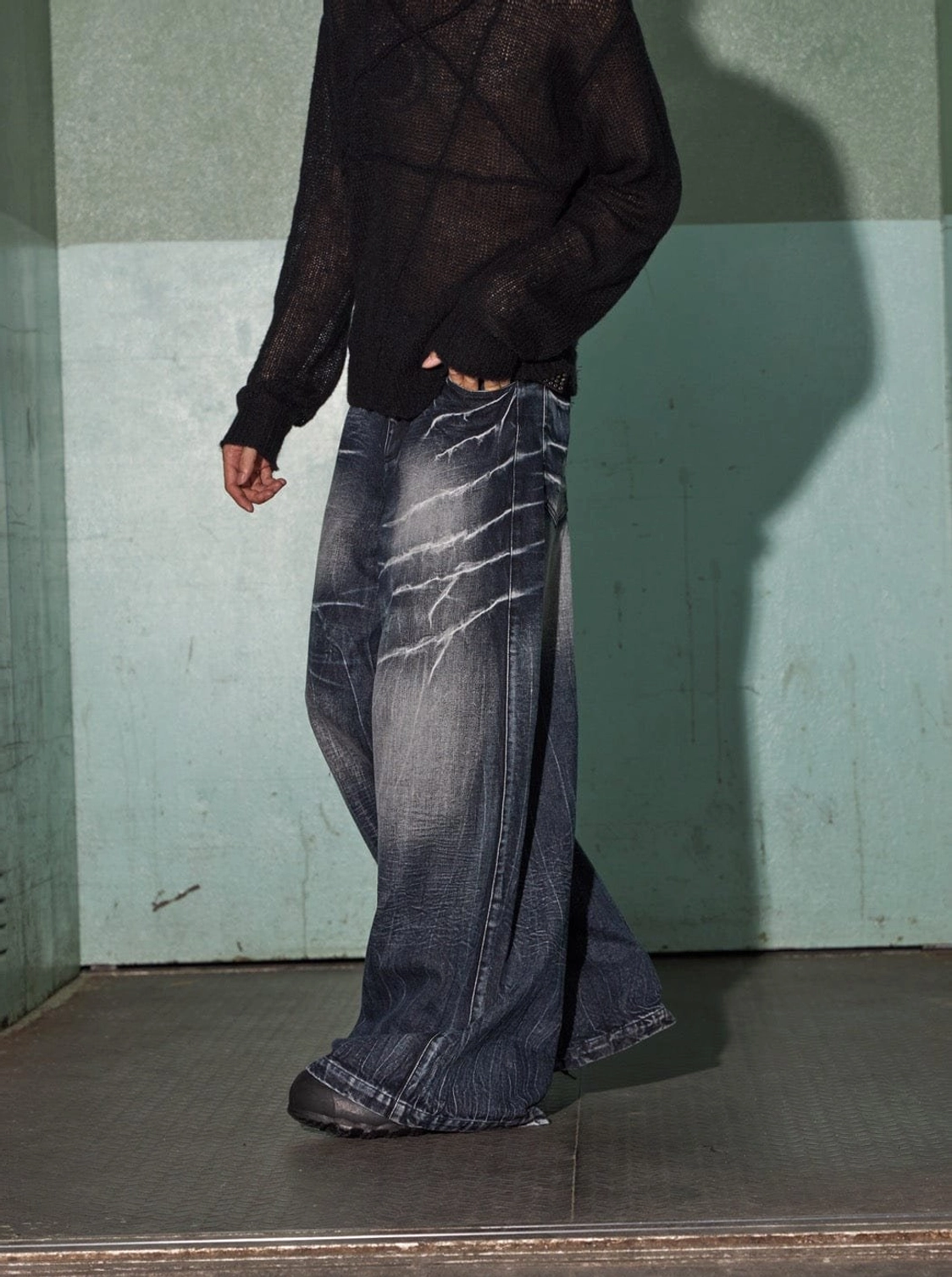 Walking three-quarter view of relaxed baggy lightning wash jeans styled for Korean streetwear fashion