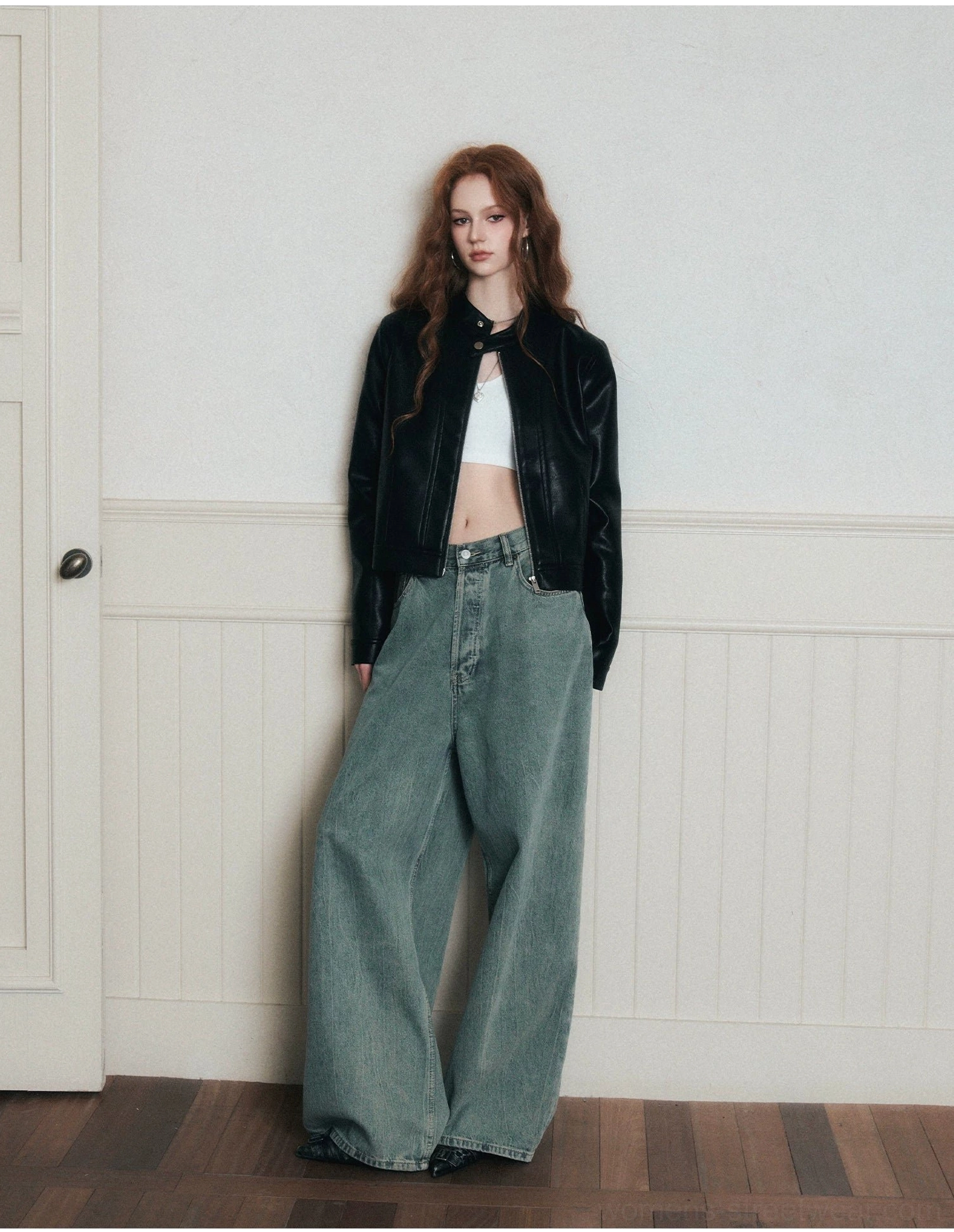 Full front side view of baggy vintage wide-leg jeans styled with a cropped black leather jacket and white tank top
