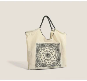 Off white bandana paisley drawstring market tote bag with black dotted shoulder straps front studio view