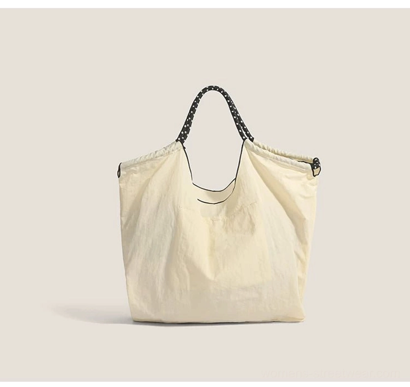 Off white streetwear drawstring market tote bag with black dotted straps and relaxed shopper silhouette