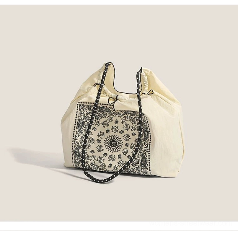 Off white bandana paisley streetwear tote bag shown from side angle with long dotted shoulder straps