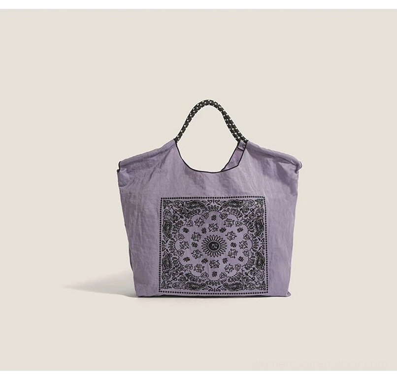 Purple bandana paisley drawstring market tote bag with black dotted shoulder straps front view