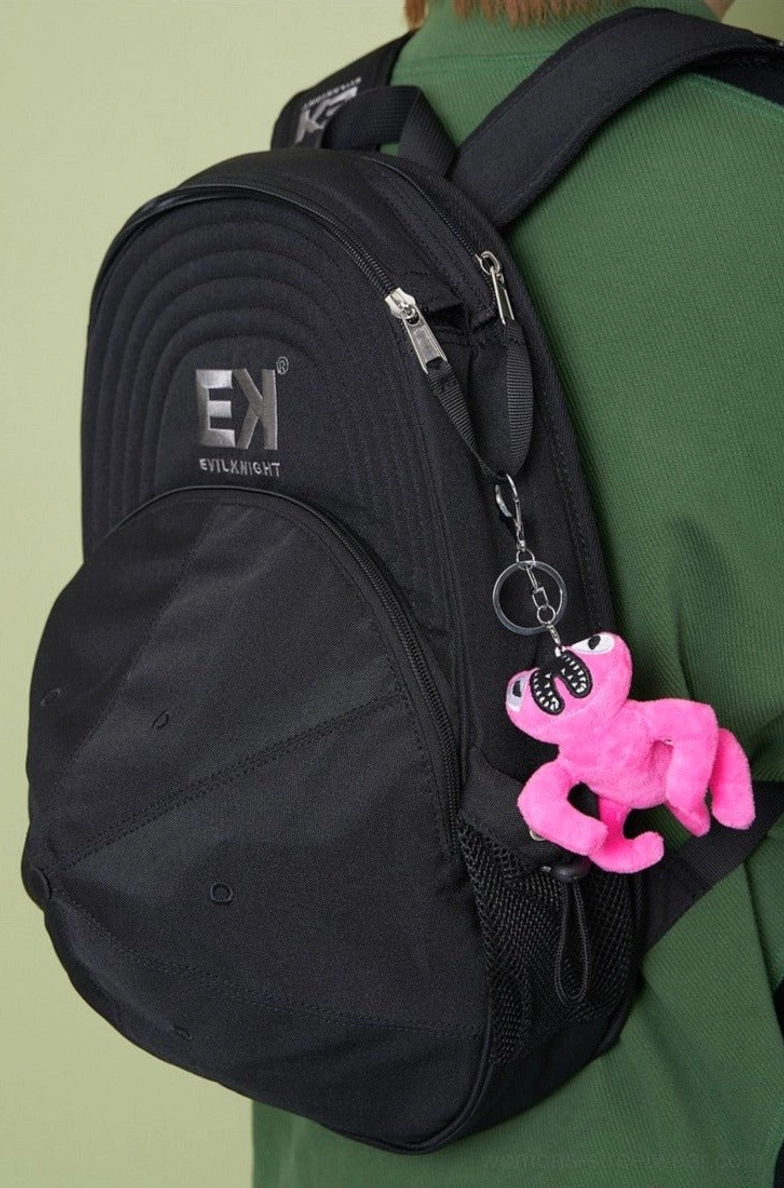 Black baseball cap silhouette streetwear backpack worn from rear three-quarter view with side mesh pocket and plush keychain accessory