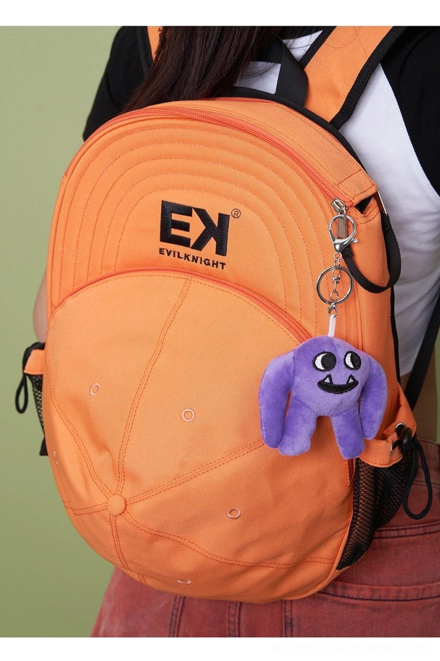 Orange baseball cap silhouette streetwear backpack worn from rear three-quarter view with colorful plush pendant