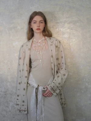 Beaded embroidered linen blazer and coordinated slip dress suit in neutral beige with layered necklace styling