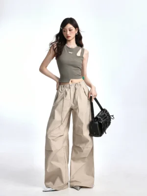 Bean Paste Green asymmetric cutout ribbed crop tank front view styled with khaki wide leg cargo pants and black ruched shoulder bag