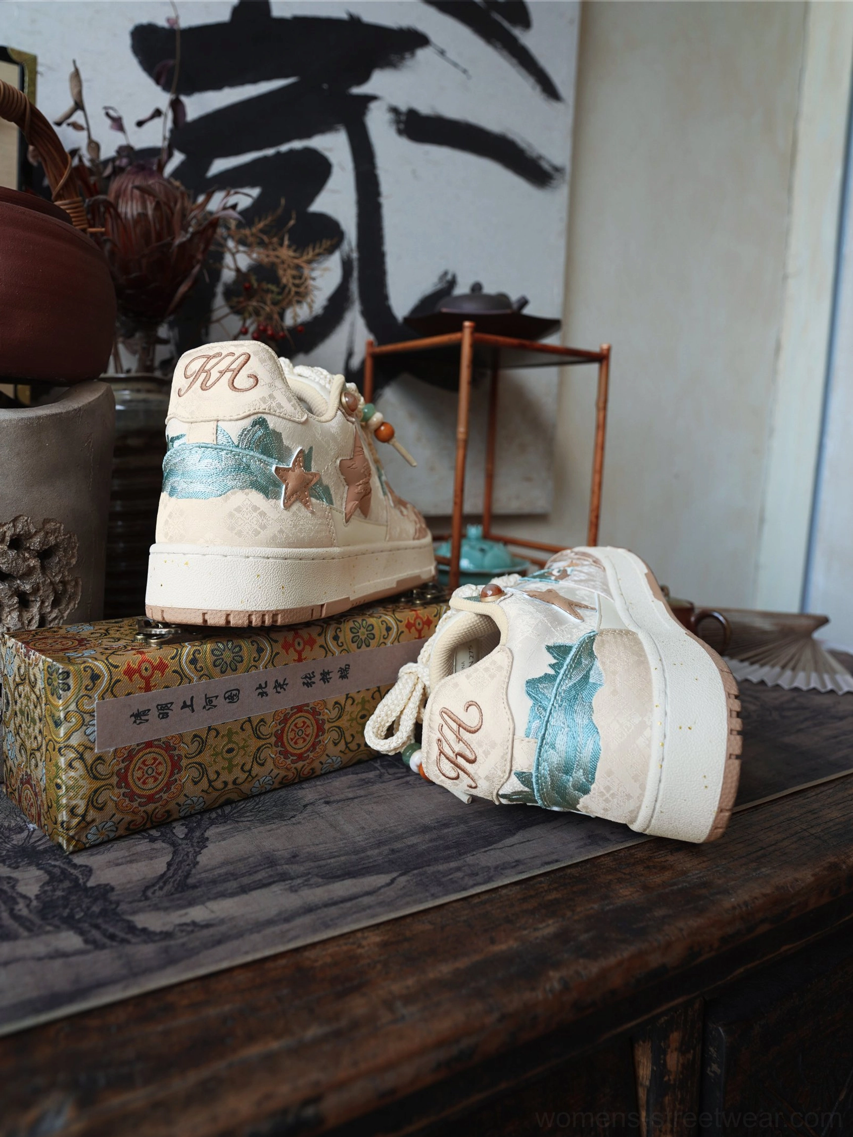 Close-up product view of beige and brown jacquard sneakers featuring layered stars and retro streetwear details