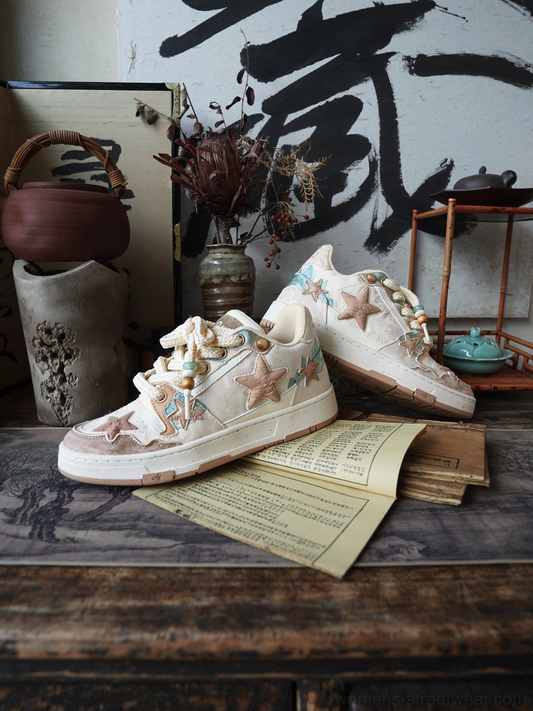Three-quarter view of beige and brown oriental retro star court sneakers on vintage paper with calligraphy and tea decor