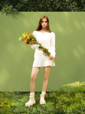 Model wearing beige chunky short rain boots with an all white neutral streetwear outfit outdoors