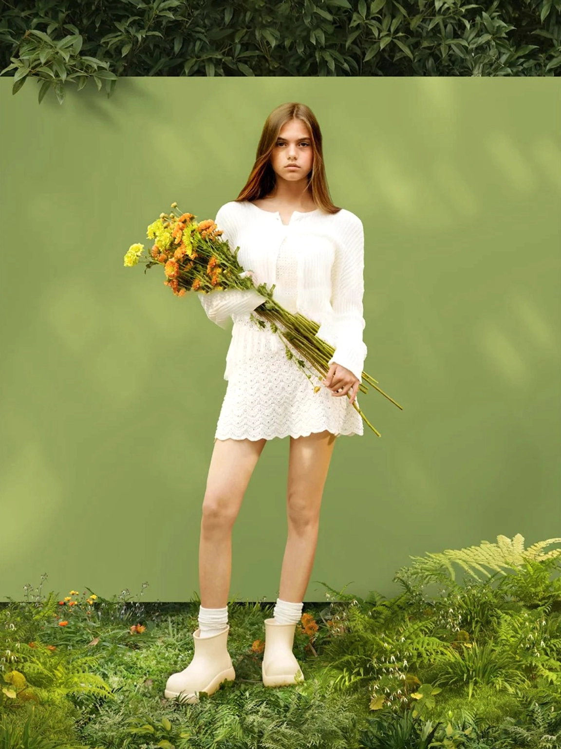 Model wearing beige chunky short rain boots with an all white neutral streetwear outfit outdoors