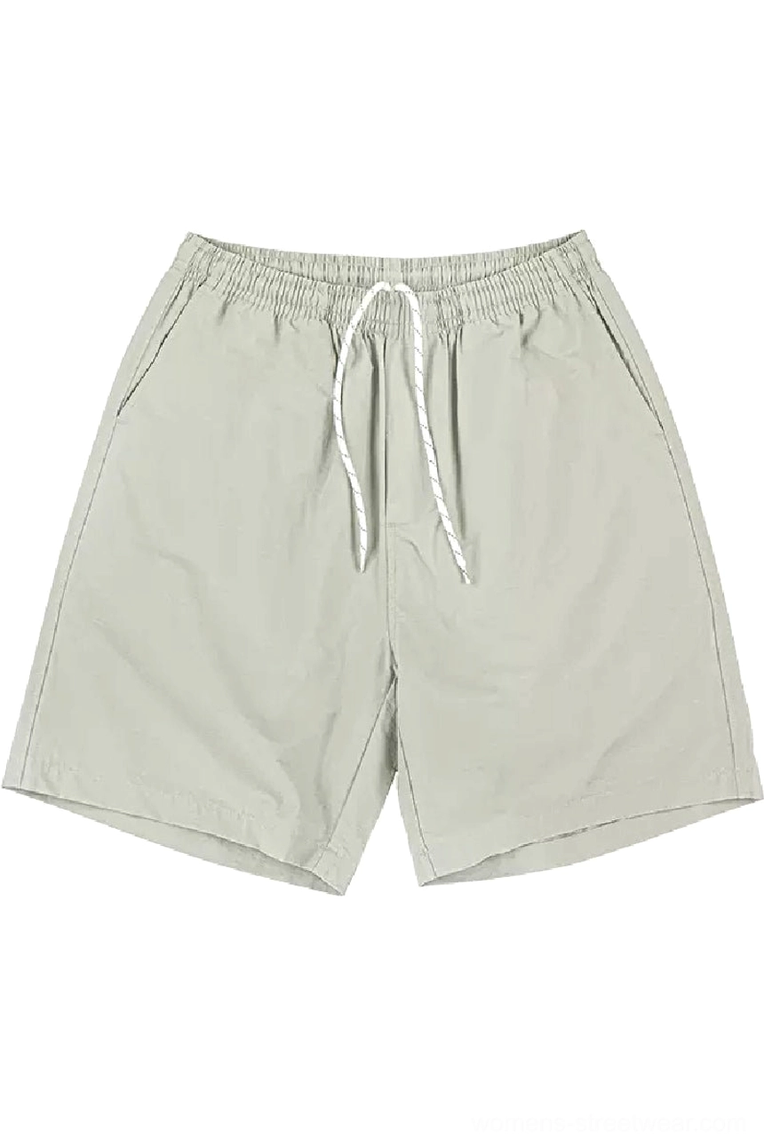 Beige cotton casual beach shorts with elastic waist, white drawstring, side pockets, and relaxed streetwear fit