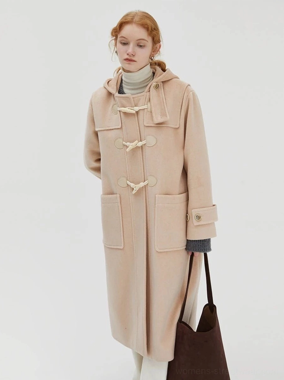 Light beige mid-length hooded duffle coat front full body model with leather shoulder bag