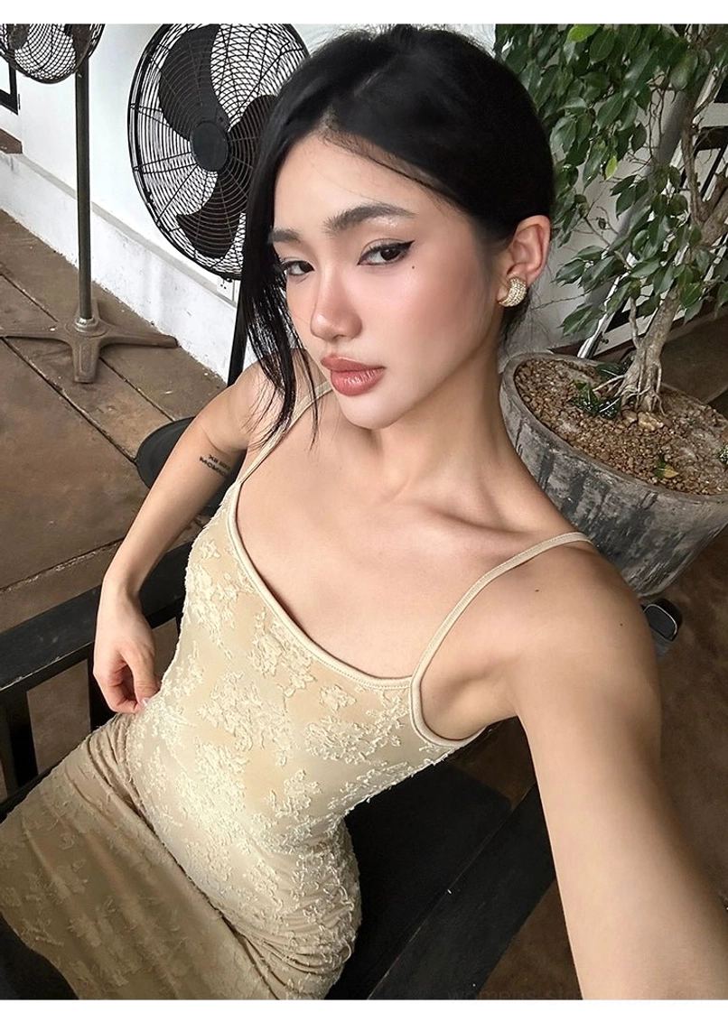 Close-up upper-body view of beige floral lace dress with embossed texture square neckline and delicate spaghetti straps