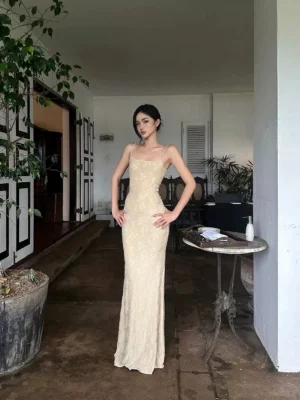 Beige lace slip maxi dress with square neckline thin spaghetti straps and tailored bodycon silhouette shown from the front