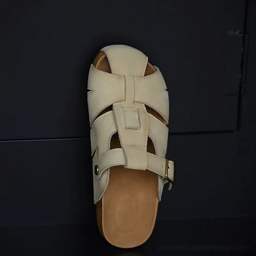Beige leather fisherman sandals with woven cutout upper, rounded closed toe, adjustable gold-tone buckle strap, and layered cork-style sole shown from a top-down view