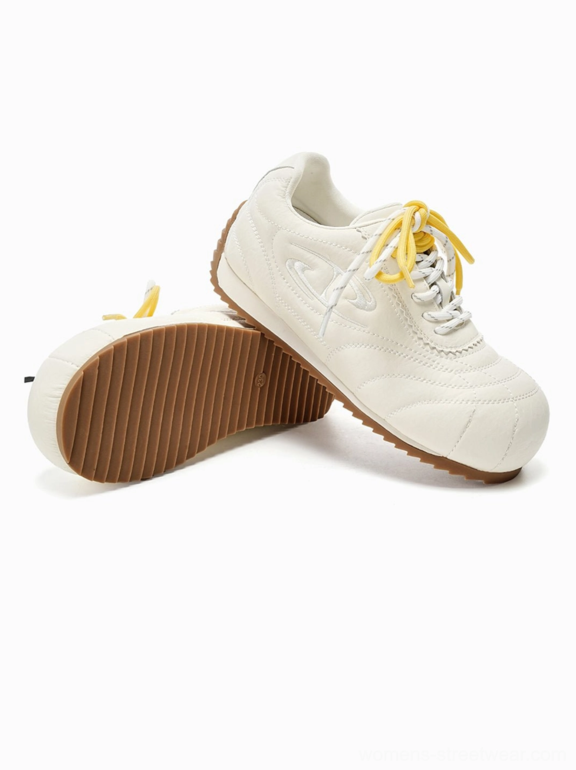 Beige low-profile retro streetwear trainer showing textured anti-slip gum rubber outsole and layered upper details