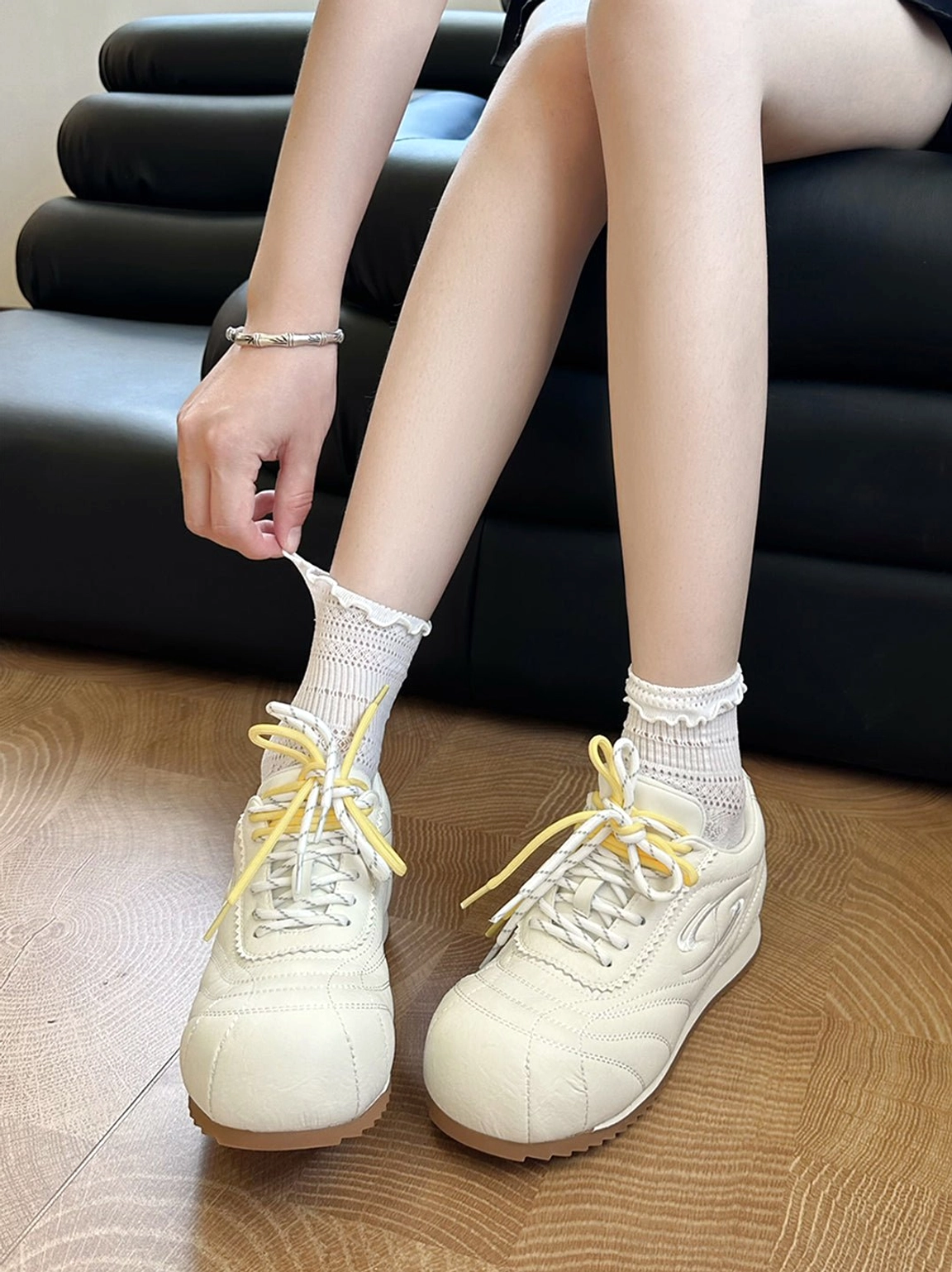 Beige low-profile retro trainers worn with frilled white ankle socks in an everyday Korean streetwear outfit