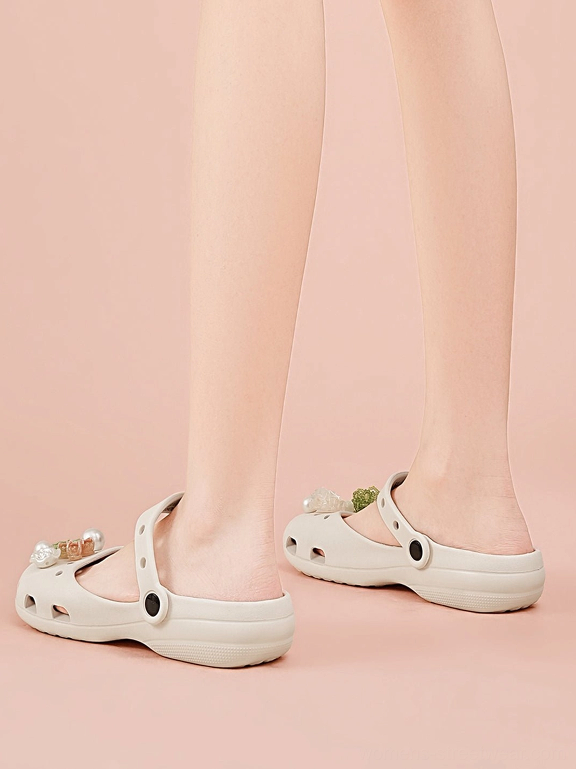 Back view of beige Mary Jane slide sandals worn on feet showing adjustable buckle heel straps and breathable hollow design