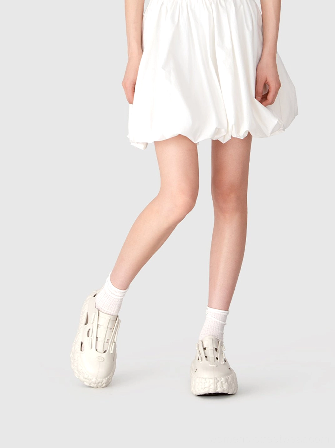 Side view of beige star platform sandals styled with white crew socks and a bubble mini skirt for a Y2K streetwear look