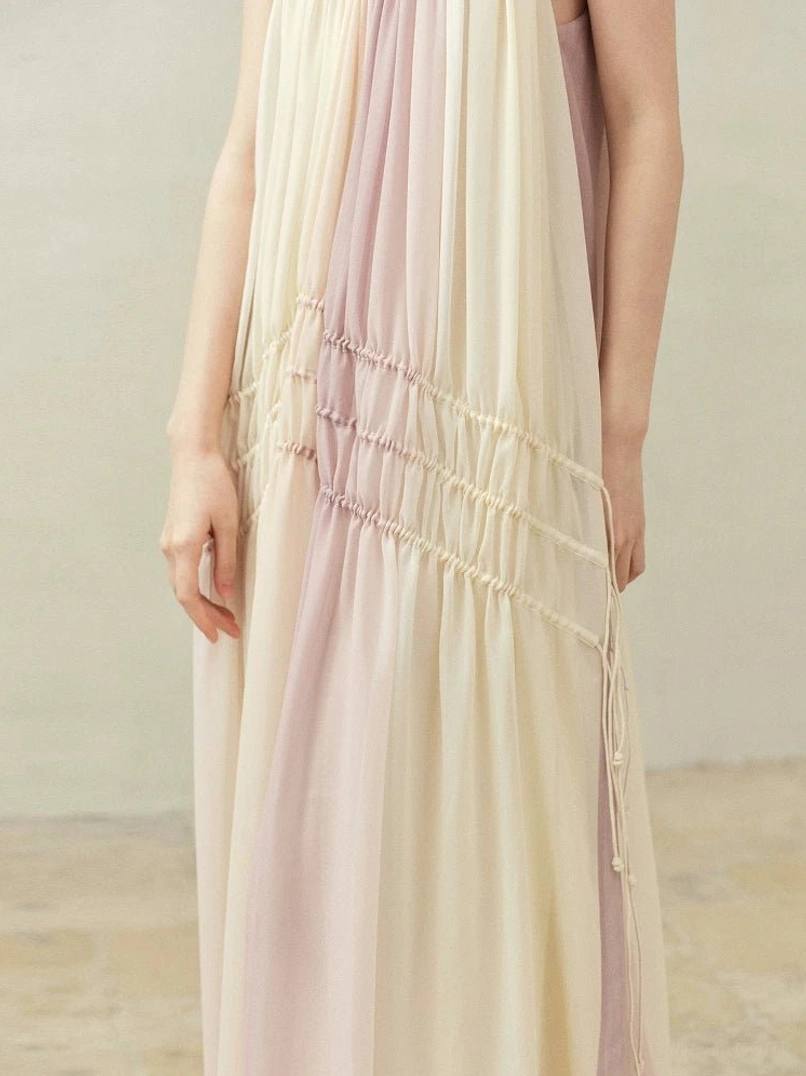 Close-up of front drawstring ruching and tassel details on beige purple gradient slip dress