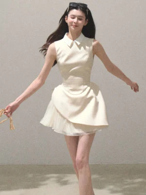 Beige sculpted draped mini dress with white contrast collar, fitted waist, asymmetric skirt and sheer tulle hem front view