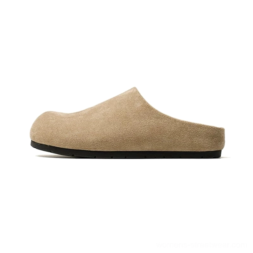 Beige suede-effect closed-toe slip-on mule clog shown in left side profile with rounded toe, open heel, and black flat outsole