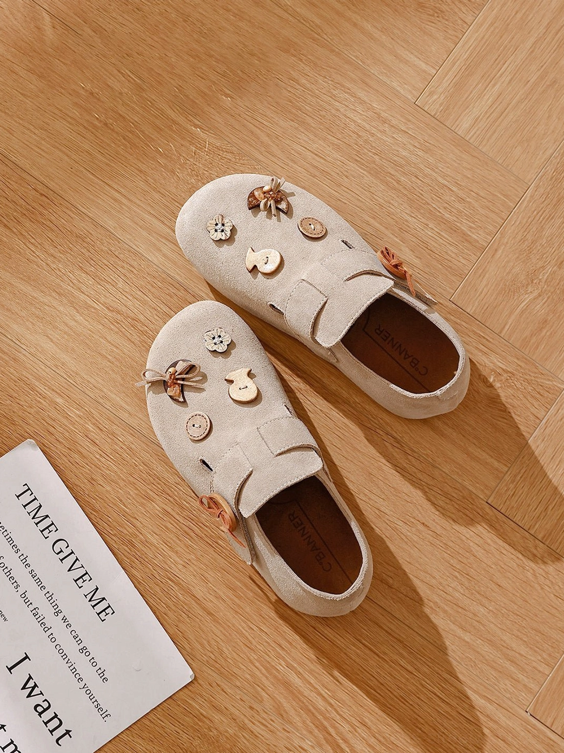 Beige two-way suede-look slip-on shoes with decorative buttons and leather-look insole styled with vintage newspaper