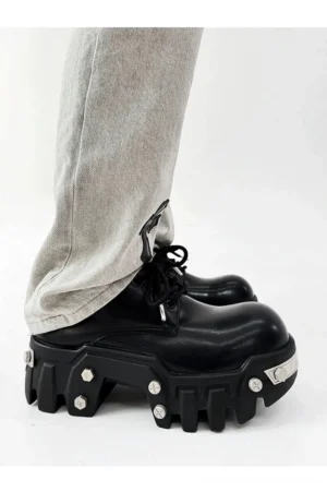Black 8cm platform Oxford shoe with polished synthetic leather upper, chunky lug sole, and silver decorative studs styled with light gray embroidered streetwear denim