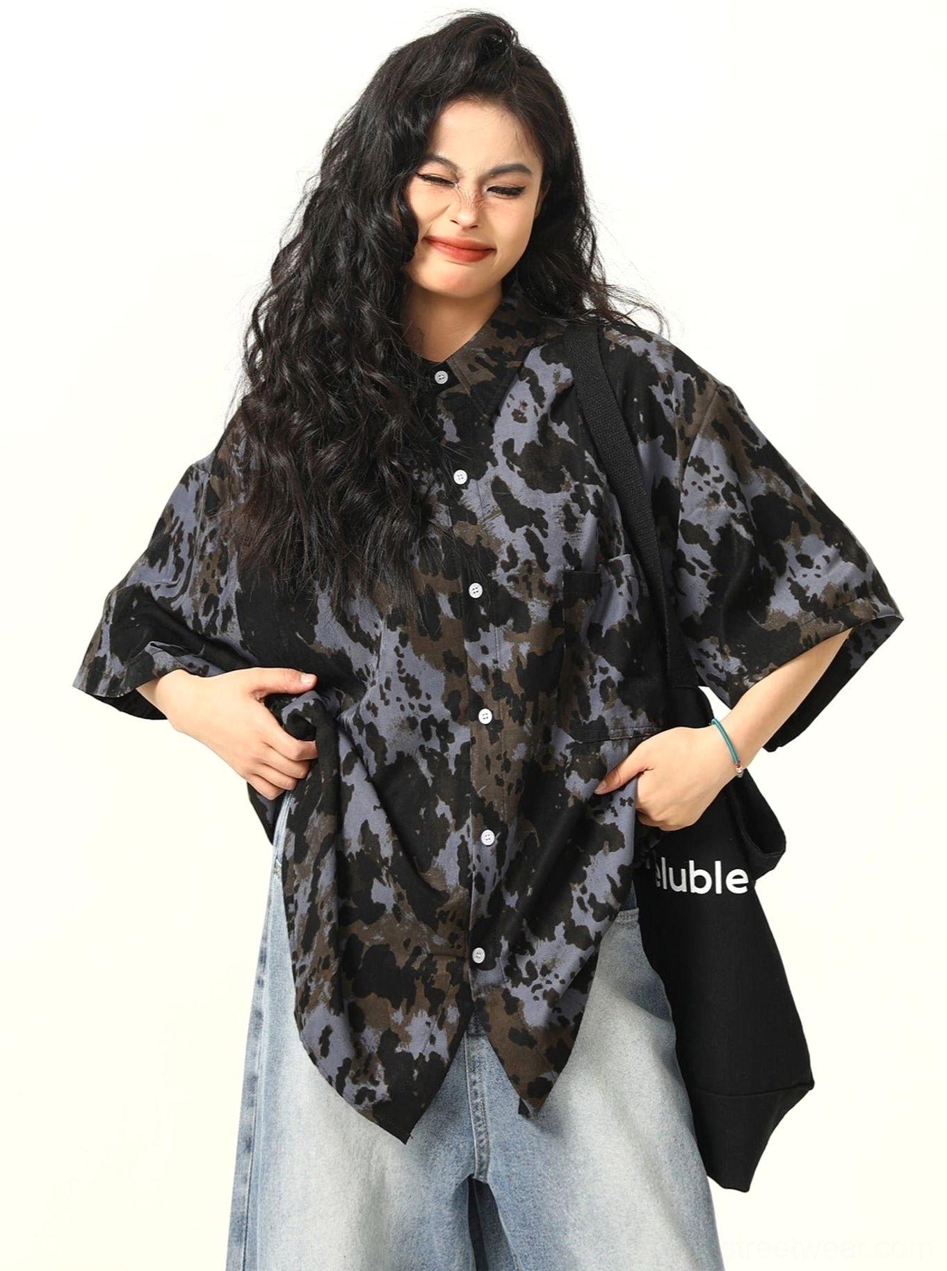 Black abstract tie-dye oversized button-up shirt styled with wide-leg denim pants and black canvas tote bag