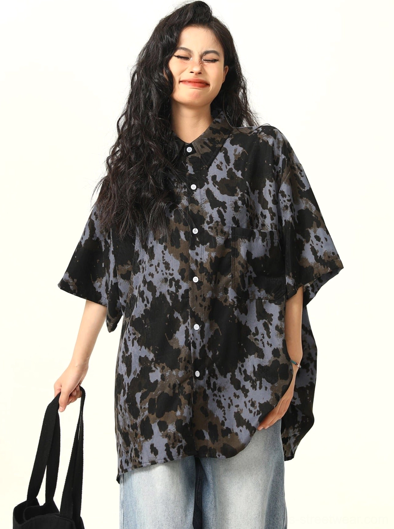 Side front view showing dropped shoulders and short sleeves on black abstract tie-dye oversized shirt