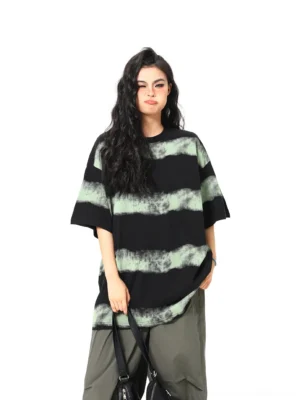 Front view of a black acid wash striped oversized T-shirt with faded mint-green horizontal stripes, relaxed crew neck, and short sleeves styled with grey cargo pants