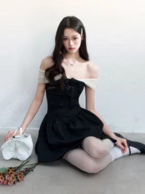 Black contrast off-shoulder bow mini dress styled with a light mesh neckline, fitted waist, flared skirt, white handbag, and romantic Korean streetwear accessories