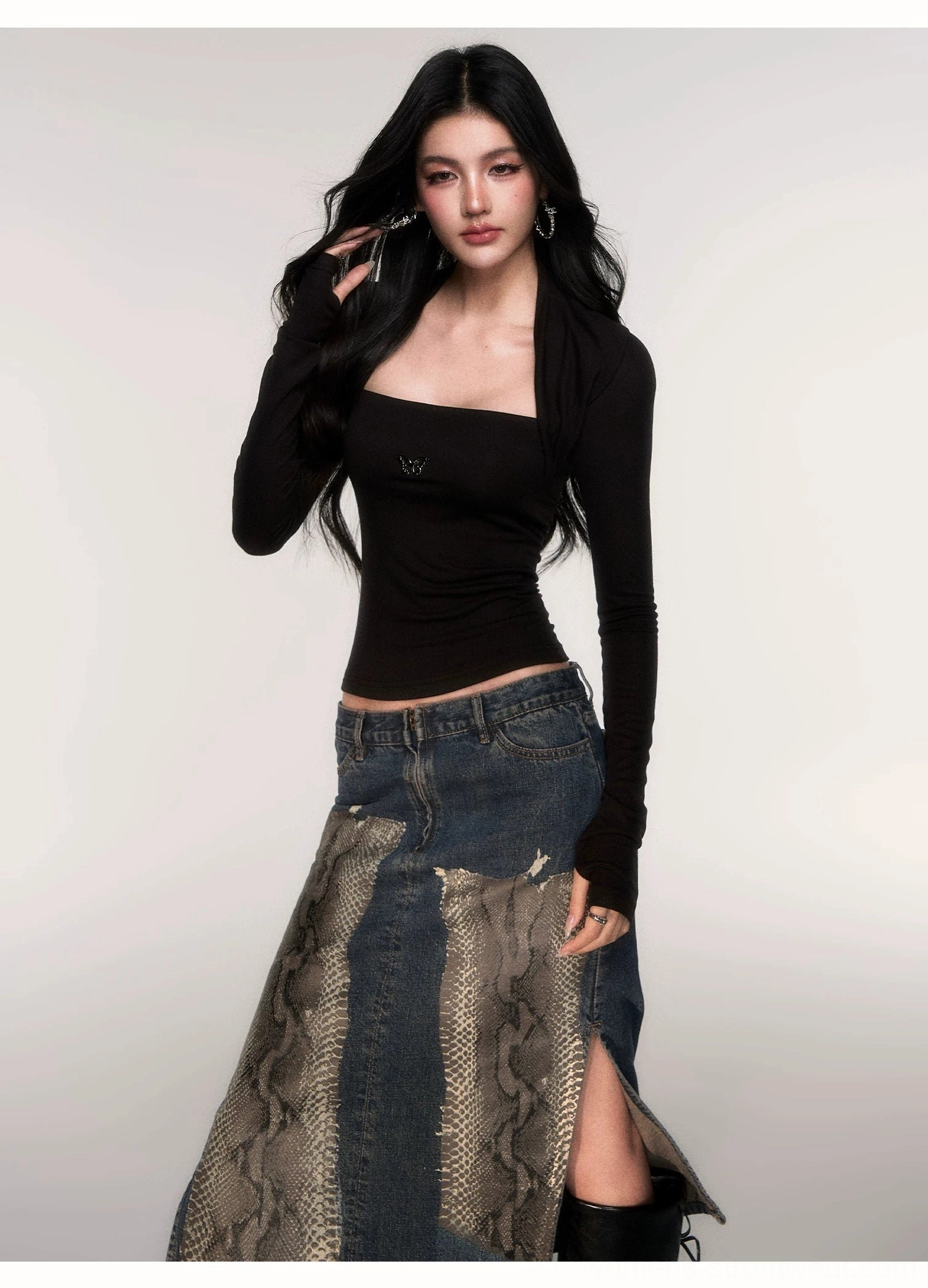 Black Acubi ribbed knit top with attached shrug, exposed shoulders, fitted long sleeves, butterfly emblem, and snake-print denim skirt