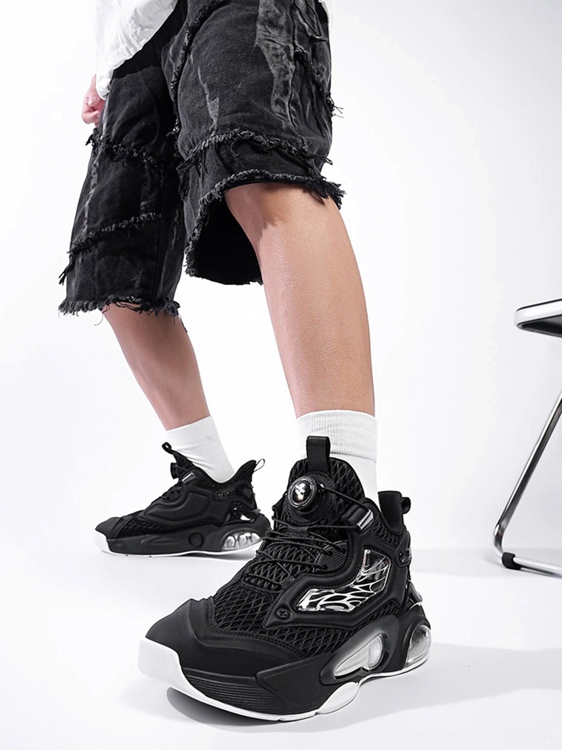 Black air cushion running sneakers styled with frayed black denim shorts and white socks